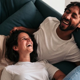a couple laughing on a couch